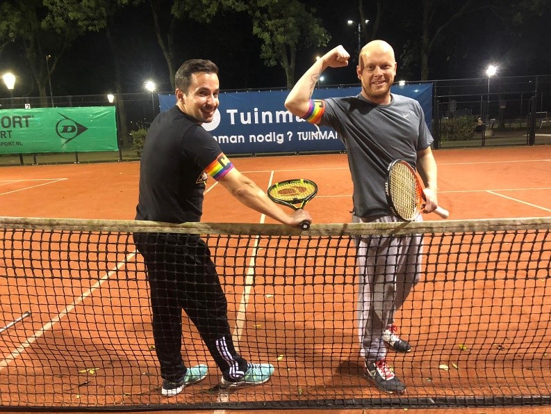 A person standing next to a net on a court with a racket
Description automatically generated